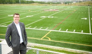 Image of Head of School Jason Rogers in front of the Rundle College football field