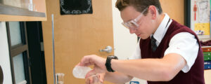 A young man in a science lab working on a project