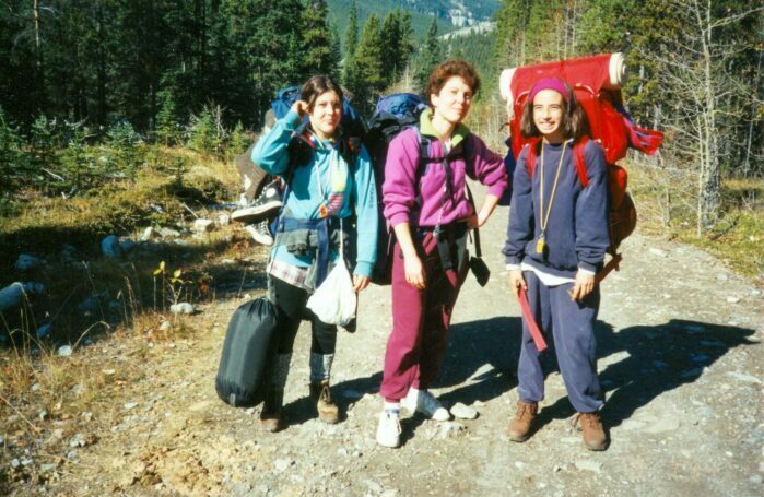 Rundle College teacher posing with two students as they walk through nature. 