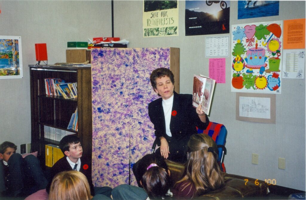 Rundle College Teacher Reading a book to a class of students.