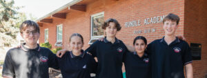 Group of Rundle Academy students smiling together outside the school building.