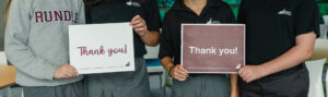 Four Rundle students hold on to thank you signs